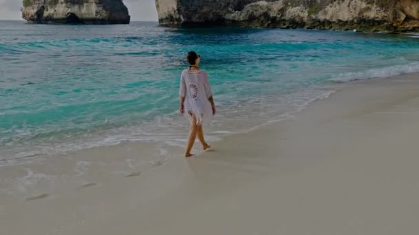 Vrouw lopend op een strand bij Diamond Bay, Nusa Penida eiland, Indonesië — Stockvideo