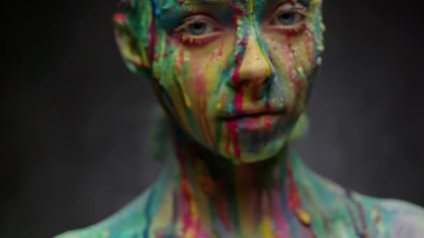 Mujer joven cubierta con una pintura colorida — Vídeos de Stock