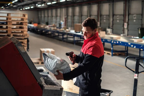 Koerier pikt pakket op in een pakhuis — Stockfoto