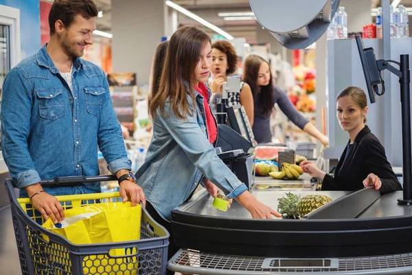 Couple buying goods in a grocery store — 스톡 사진