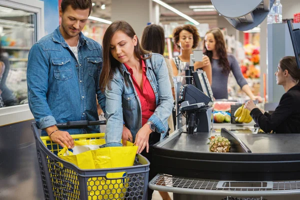 Couple buying goods in a grocery store — 스톡 사진