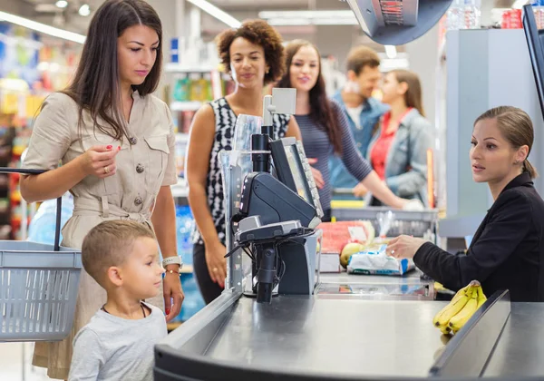 Woamn com um filho em um supermercado — Fotografia de Stock