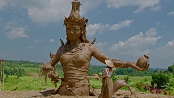 Mujer cerca de Estatua de la Diosa de la fertilidad en la terraza de arroz Jatiluwih, Bali — Vídeos de Stock