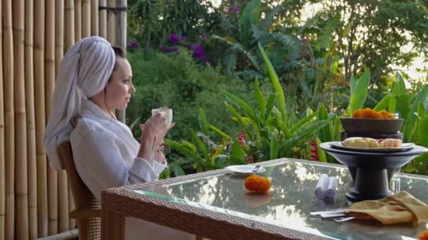Kobieta delektująca się kawą na tarasie w tropikalnym kraju — Wideo stockowe