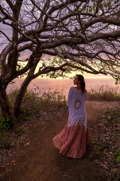 Mujer disfrutando del atardecer cerca del océano — Foto de Stock