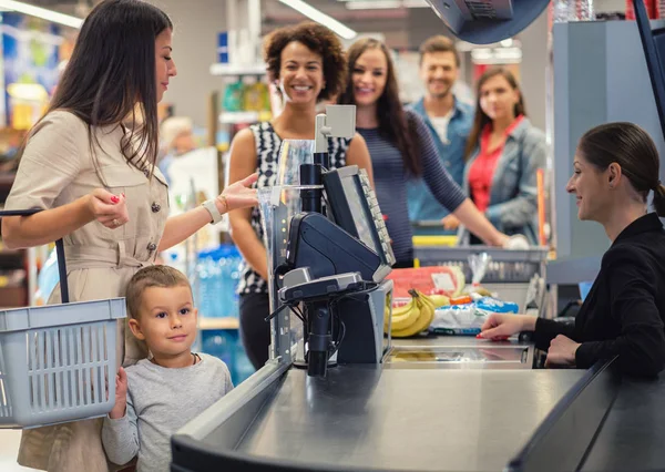 Woamn met een zoon in een supermarkt — Stockfoto