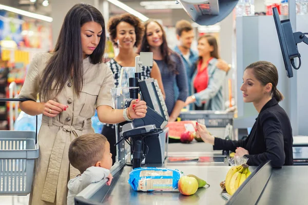 Woamn com um filho em um supermercado — Fotografia de Stock