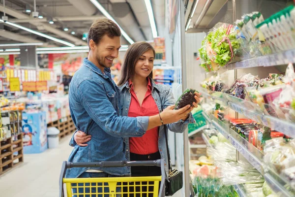 Couple choosing goods in a grocery store — Stock Photo, Image