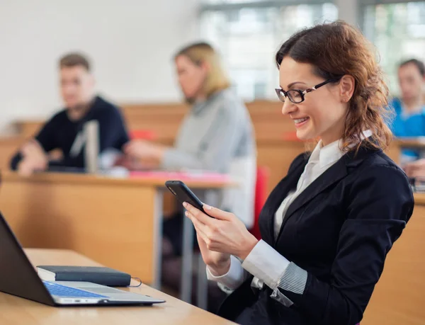 Estudante com telefone celular em auditório — Fotografia de Stock