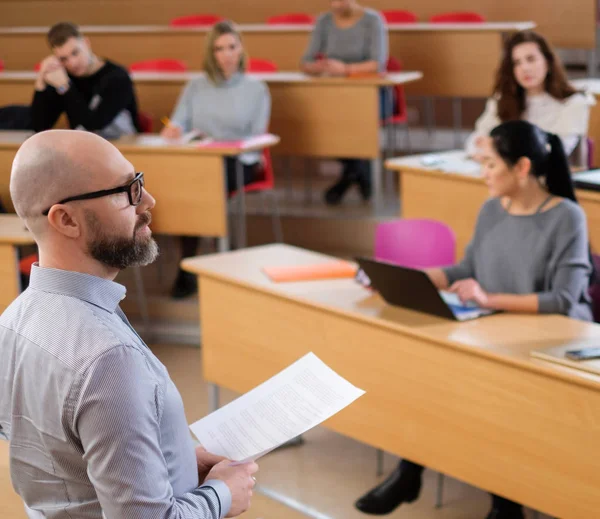 Chargé de cours et groupe multinational d'étudiants dans un auditorium — Photo