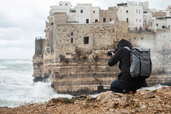 Photographer taking picture of a stormy sea in Polignano a Mare, Italy — Stock Photo, Image