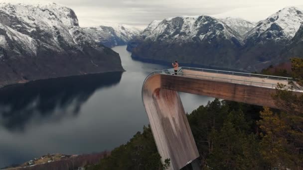 Az ember Stegastein szemszögéből Aurlandsfjord felett Norvégiában — Stock videók