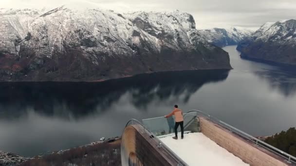 Man op Stegastein uitkijkpunt boven Aurlandsfjord in Noorwegen — Stockvideo