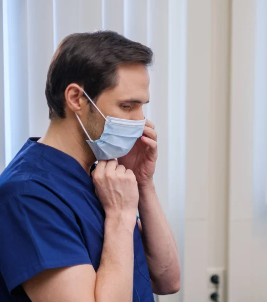 Hastanede koruyucu maske takan bir doktor. — Stok fotoğraf