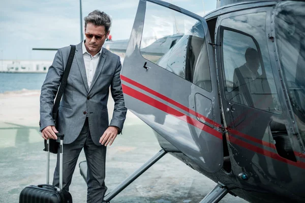 Бізнесмен стоїть біля приватного вертольота — стокове фото