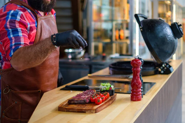 Chef salga bife antes de grelhar em um restaurante — Fotografia de Stock