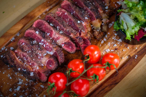 Servindo bife de carne cozido na hora em uma placa de madeira — Fotografia de Stock