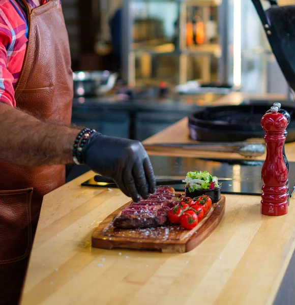 Chef salga bife antes de grelhar em um restaurante — Fotografia de Stock