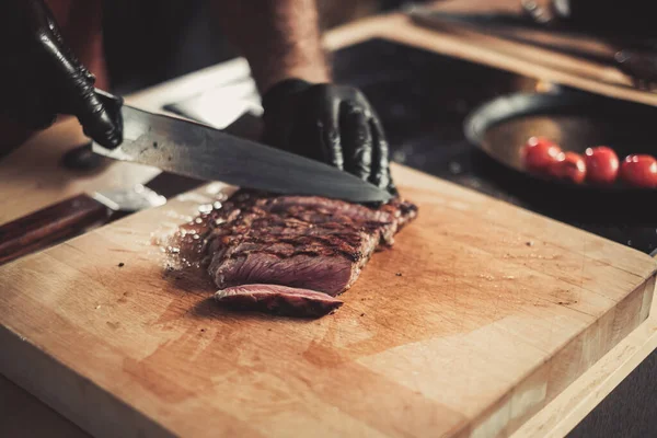 Chef cortando bifes de carne em um restaurante — Fotografia de Stock