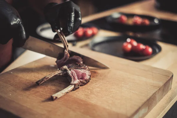 Chef cortando costelas recém-cozidas em um restaurante — Fotografia de Stock