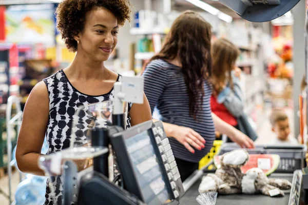 Zwarte vrouw koopt goederen in een supermarkt — Stockfoto