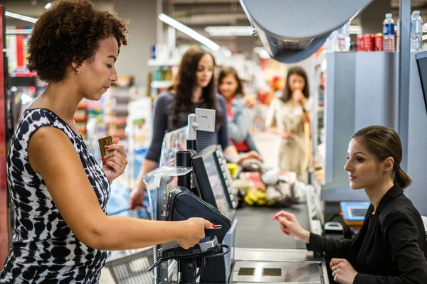 Черная женщина покупает товары в продуктовом магазине — стоковое фото