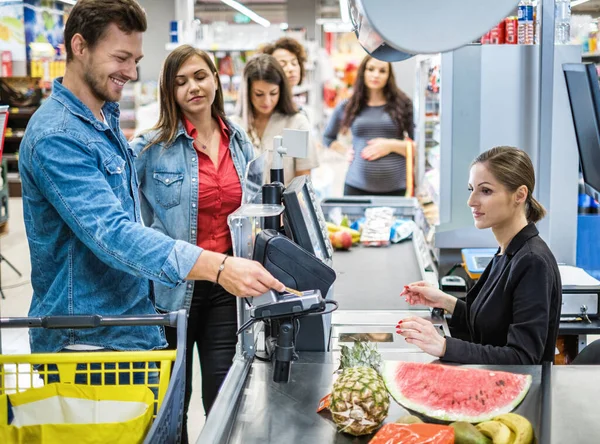 People buying goods in a grocery store — Stock Photo, Image