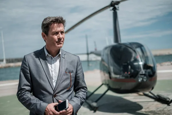 Zakenman in de buurt van een privé helikopter — Stockfoto