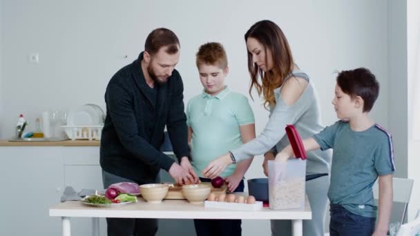 Счастливая семья готовит вместе дома — стоковое видео