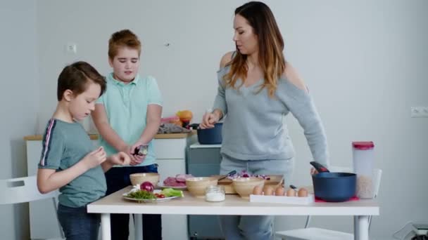 Счастливая семья готовит вместе дома — стоковое видео