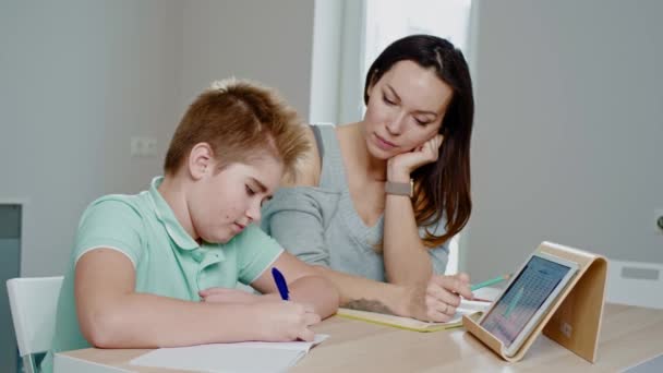 Madre con su hijo estudiando en línea en casa — Vídeos de Stock