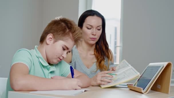 Madre con su hijo estudiando en línea en casa — Vídeo de stock