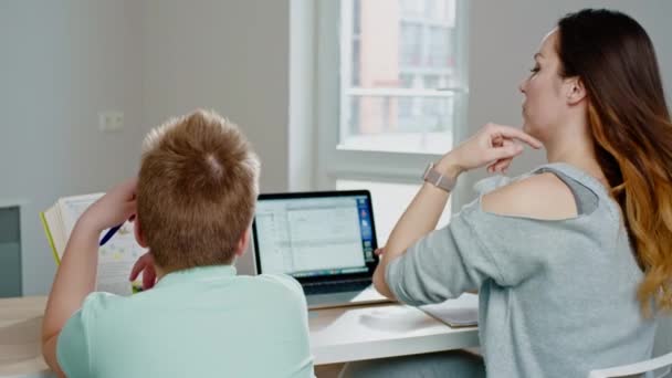 Madre con su hijo estudiando en línea en casa — Vídeos de Stock