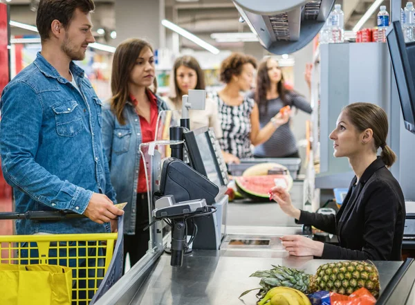 Pessoas comprando mercadorias em uma mercearia — Fotografia de Stock