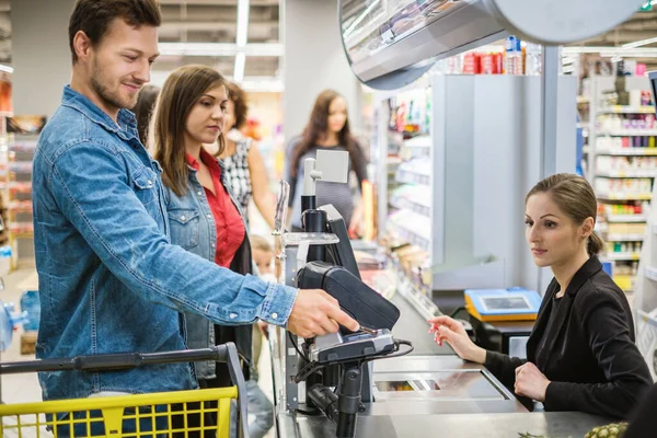 Man paying with contactless card in a grocery store — Stock Photo, Image
