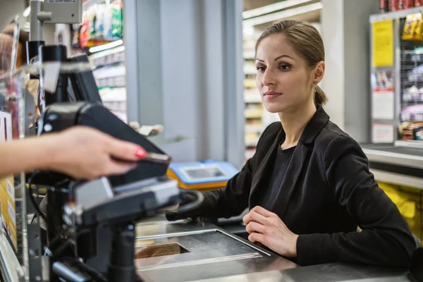 식품점에서카 스마트폰으로 돈을 지불하는 모습 — 스톡 사진