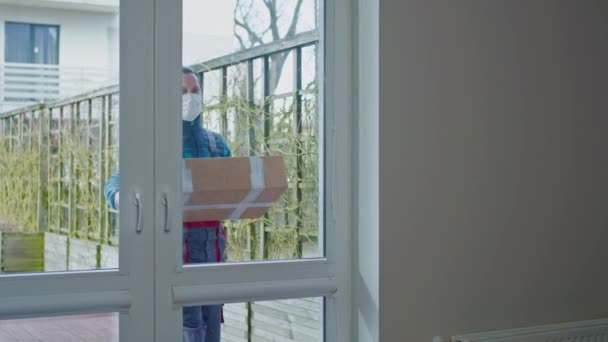 Courier skyddas med mask och handskar leverera paket till en kund — Stockvideo