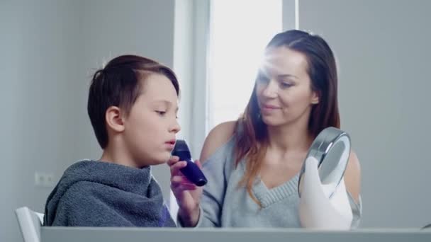 Madre haciendo un corte de pelo a su hijo — Vídeos de Stock