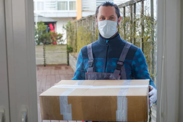 Courier skyddas med mask och handskar leverera paket till en kund — Stockfoto