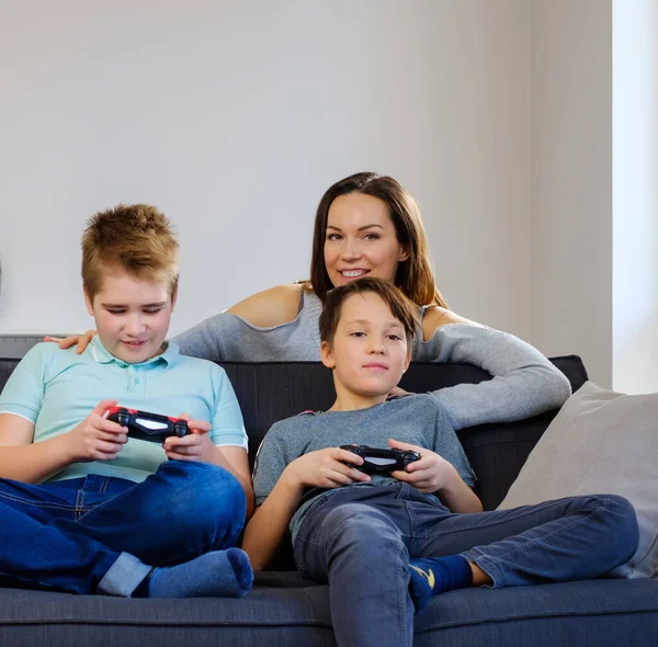 Moeder en gelukkige kinderen spelen videospel thuis — Stockfoto