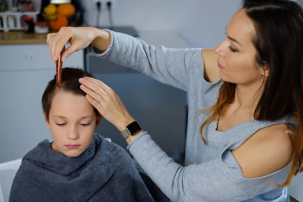 Moeder het maken van haar zoon een kapsel — Stockfoto