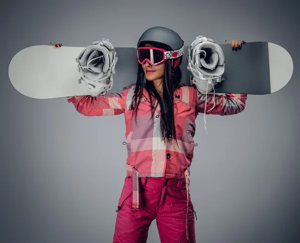 Mujer sosteniendo una tabla de snowboard sobre sus hombros — Foto de Stock