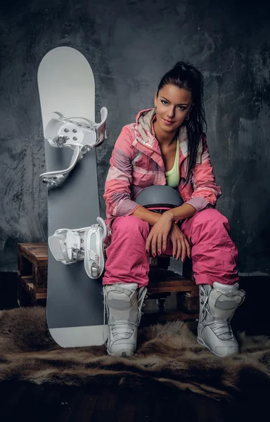 Женщина в розовом костюме сноубордистки — стоковое фото