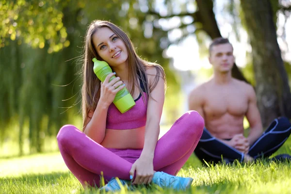 Paar entspannt sich nach Yoga-Übungen im Gras — Stockfoto