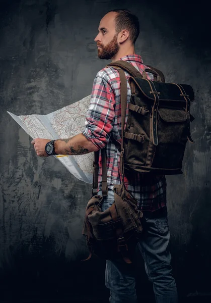 Male with backpack holding city map