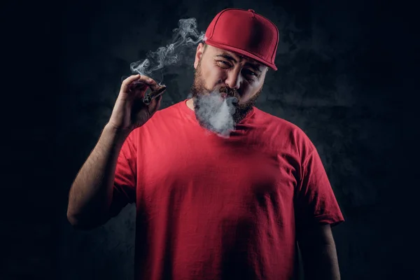 Толстый бородатый хипстер курит сигарету — стоковое фото