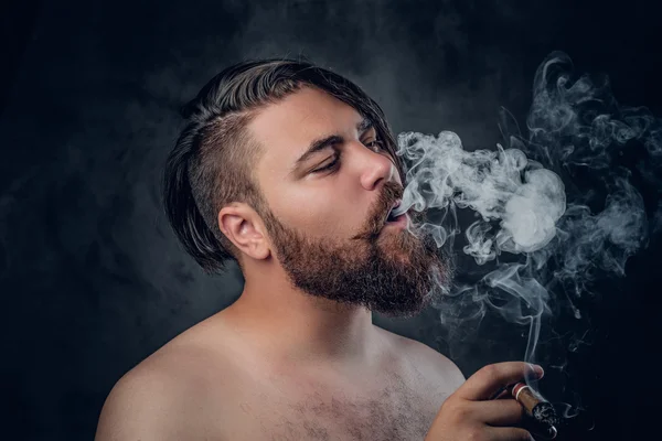 Varón barbudo fumando un cigarro —  Fotos de Stock