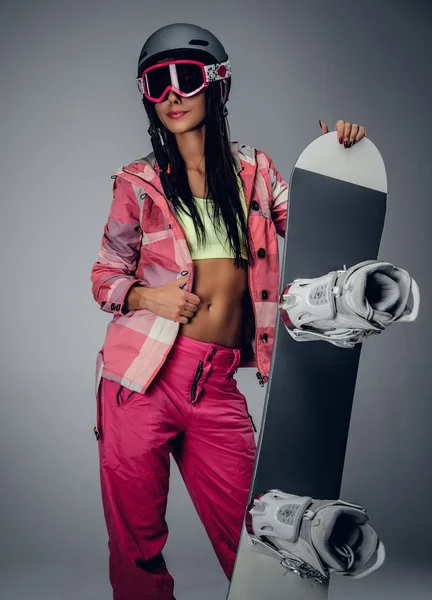 Женщина в розовом лыжном костюме с сноубордом — стоковое фото