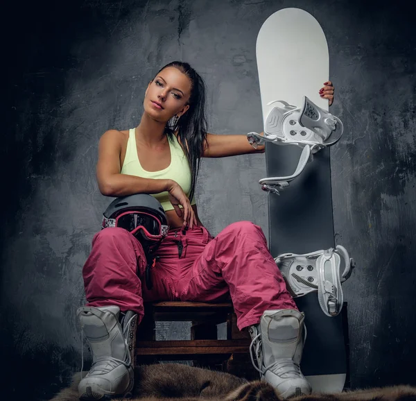 Sportig kvinna poserar med snowboard — Stockfoto