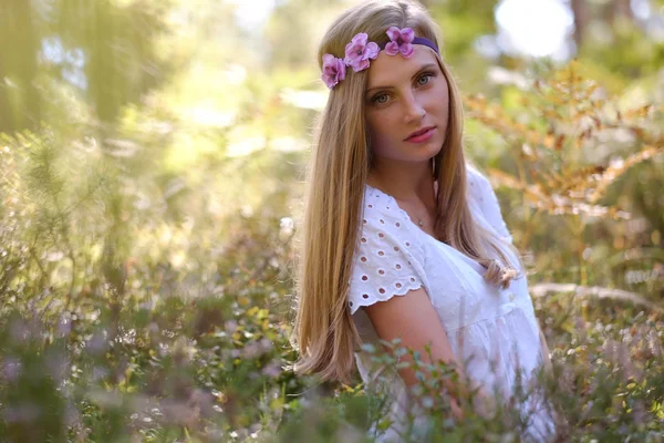 Sommersprossige Frau mit einem Kreis von Blumen — Stockfoto